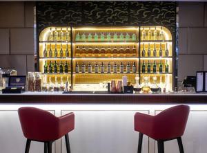 two chairs sitting at a bar with bottles of alcohol at Amari Bangkok in Bangkok