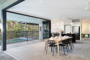 a dining room and kitchen with a table and chairs at Reef Villa - A Sprawling Waterfront Oasis in Nightcliff