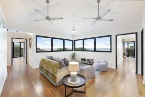 a living room with a couch and some windows at Reef Villa - A Sprawling Waterfront Oasis in Nightcliff