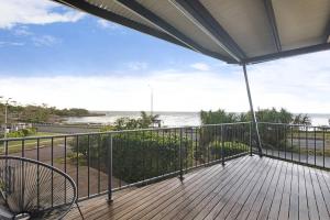 a balcony with a view of the ocean at Reef Villa - A Sprawling Waterfront Oasis in Nightcliff