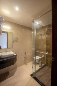 a bathroom with a glass shower and a toilet at Golden Fortune Inn Hotel in Bengaluru
