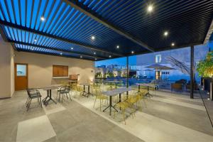 un restaurante con mesas y sillas y un patio en City Express Plus by Marriott Mazatlan en Mazatlán