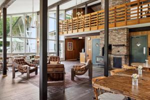 a lobby with a fireplace and tables and chairs at Mountaineer Inn in West Dover