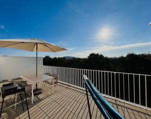 una terraza con sombrilla, mesa y banco en Gemütliche Wohnung mit Flair und Natur pur, en Viena