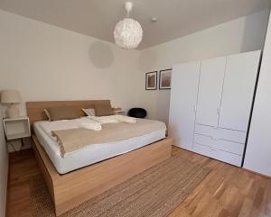 Un dormitorio con una cama grande y una lámpara de araña. en Gemütliche Wohnung mit Flair und Natur pur, en Viena