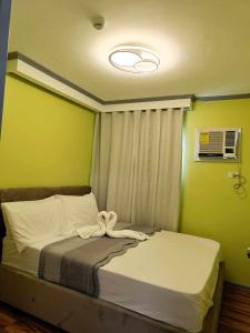 łóżko w pokoju z zielonymi ścianami w obiekcie Davao condo unit 204 w mieście Davao