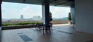 Melangok Homestay في كاجانغ: غرفة مع طاولة وكراسي ونافذة كبيرة