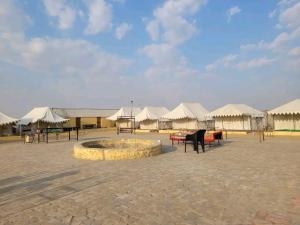 a group of tents with tables and benches in a courtyard at Hindustan Desert Camp in Kūri