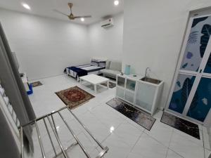 a white living room with a couch and a table at Esah Best INN in Muar