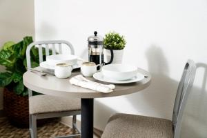 a table with plates and cups and a coffee maker on it at InTown Suites Extended Stay Atlanta GA - Forest Park in Forest Park