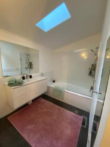y baño con bañera, lavabo y espejo. en Sassafras Treehouse Private home in the Dandenong Ranges, Victoria, en Sassafras