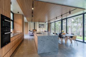 a kitchen with a large island and a table with chairs at Boomerang House I Private Properties in Quindalup