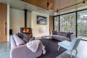 a living room with two couches and a fireplace at Boomerang House I Private Properties in Quindalup +17 photos