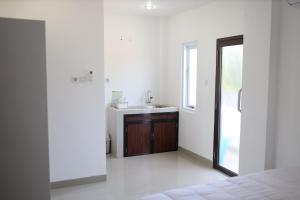een witte badkamer met een wastafel en een spiegel bij Urbanview Hotel Eropa Maros Near Sultan Hasanuddin Airport in Maros