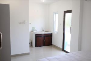 uma casa de banho branca com um lavatório e um espelho em Urbanview Hotel Eropa Maros Near Sultan Hasanuddin Airport em Maros