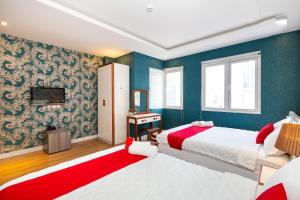 a bedroom with two beds and a television in it at Spring Airport Hotel in Ho Chi Minh City