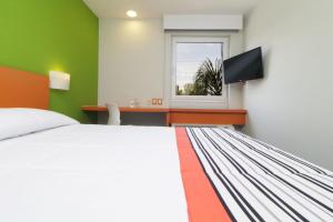 a bedroom with a bed and a desk and a window at City Express Junior by Marriott Toluca Aeropuerto in Toluca