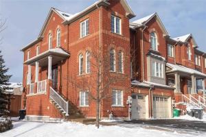 a large red brick building with snow on the ground at Jazzy Home Stay in Mississauga