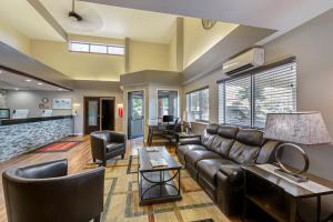 - un salon avec un canapé et des fauteuils en cuir dans l'établissement Baymont by Wyndham Missoula, à Missoula