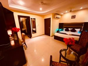 a hotel room with a bed and a table and chairs at The Reo Luxury Hotel - Haridwar in Haridwār