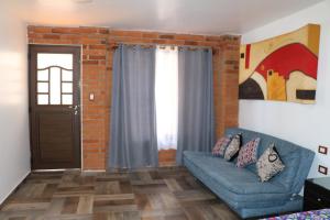 a living room with a blue couch and a brick wall at Alojamiento HM in Cholula