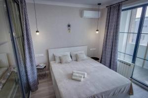 a bedroom with a bed with two towels on it at Asaapart Ush-Sunkar 153 in Almaty