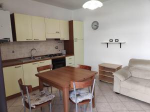cocina con mesa, sillas y sofá en Casa del Sole en Riotorto