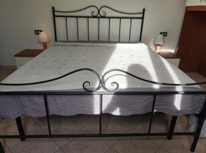 1 cama grande con colcha blanca y 2 lámparas en Casa del Sole en Riotorto