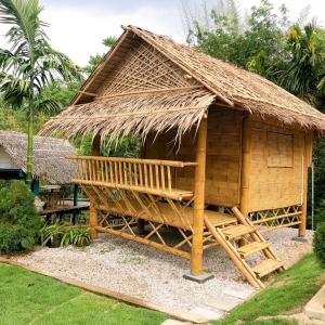 uma pequena cabana com um telhado de palha e uma escada em คุ้มกะลาหัวฟาร์มสเตย์ (Khumkalahua Farmstay) em Ban Pha Saeng Lang