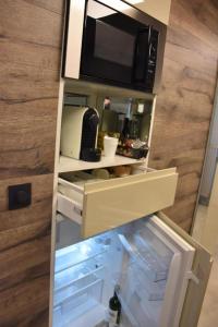 an open refrigerator with a microwave on top of it at Flat 40 by Malmedreams in Malmedy