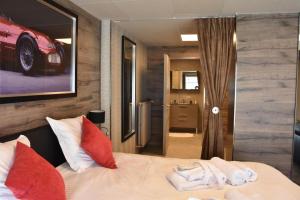 1 dormitorio con 1 cama con almohadas rojas y blancas en Flat 40 by Malmedreams en Malmedy