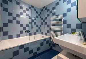 a blue and white bathroom with a tub and a sink at Panoramapark Soleil E Apt 3 in Wengen