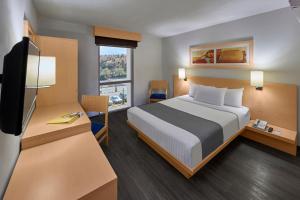 a hotel room with a bed and a television at City Express by Marriott Nogales in Nogales