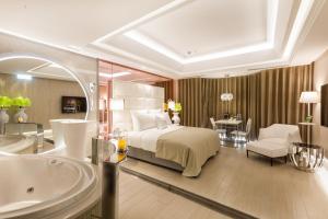 Six Star Motel-Taoyuan في تاويوان: غرفة نوم بسرير وحمام مع حوض استحمام