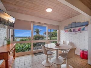 a dining room with a table and chairs and a window at Pacific Heights in Merimbula