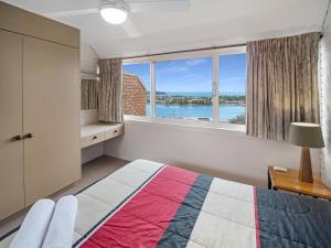 a bedroom with a bed and a large window at Pacific Heights in Merimbula +46 photos