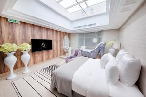 桃園市にあるSix Star Motel-Taoyuanのベッドルーム(白いベッド1台、天窓付)