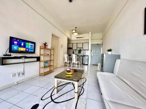 un salon avec un canapé et une table dans l'établissement Mahkota Prd Pahlawan Homestay 1Rom-4pax/free wi-fi, à Malacca