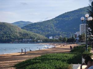 a beach with a bunch of people in the water at Fika Homestay Nguyên Căn 600m2 - Trung Tâm Quy Nhơn, Cách Biển 50m in Quy Nhon