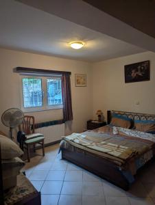 um quarto com uma cama, uma cadeira e uma janela em 1 bedroom apartment close to the sea em Artemida