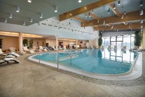 duży basen w lobby hotelowym z krzesłami w obiekcie Wellness Hotel Diamant w mieście Hluboká nad Vltavou +37 zdjęć