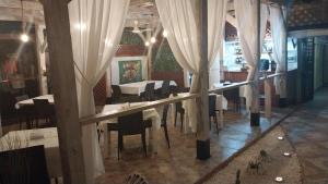 a dining room with white curtains and tables and chairs at Residencial El Mirador in Boca Chica