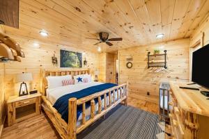 Blockhausschlafzimmer mit einem Bett und einem Schreibtisch in der Unterkunft LUXURY 4BR Cabin in Gatlinburg with Views Hot Tub with Private Deck Game Room Most Popular Coffee Bar Perfect for Family Getaway Tennis Courts Infant Crib and Karaoke System in Gatlinburg + 21 Fotos