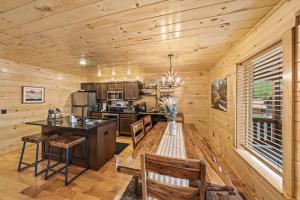 eine Küche mit Tisch und Stühlen in einer Hütte in der Unterkunft LUXURY 4BR Cabin in Gatlinburg with Views Hot Tub with Private Deck Game Room Most Popular Coffee Bar Perfect for Family Getaway Tennis Courts Infant Crib and Karaoke System in Gatlinburg