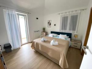1 dormitorio con 1 cama con 2 toallas en Apartments by the sea Promajna, Makarska - 2592, en Promajna