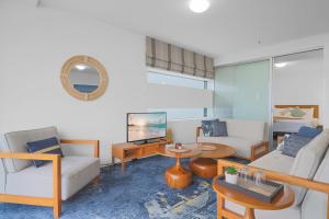 ein Wohnzimmer mit einem Sofa und einem Tisch in der Unterkunft The Reef Pad, ideally located with a stellar view! in Cairns