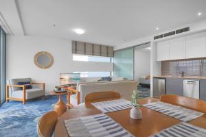 eine Küche und ein Wohnzimmer mit einem Tisch und Stühlen in der Unterkunft The Reef Pad, ideally located with a stellar view! in Cairns