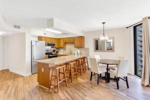 a kitchen with a counter and a table and chairs at Seaside Beach & Racquet 5614 in Romar Beach
