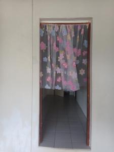 a door with a curtain with flowers on it at Bluepango Guest House in Port Vila