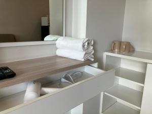 a bathroom with a shelf with towels and a mirror at 2 mins walk to BTS Bang Chak in Bangkok +6 photos